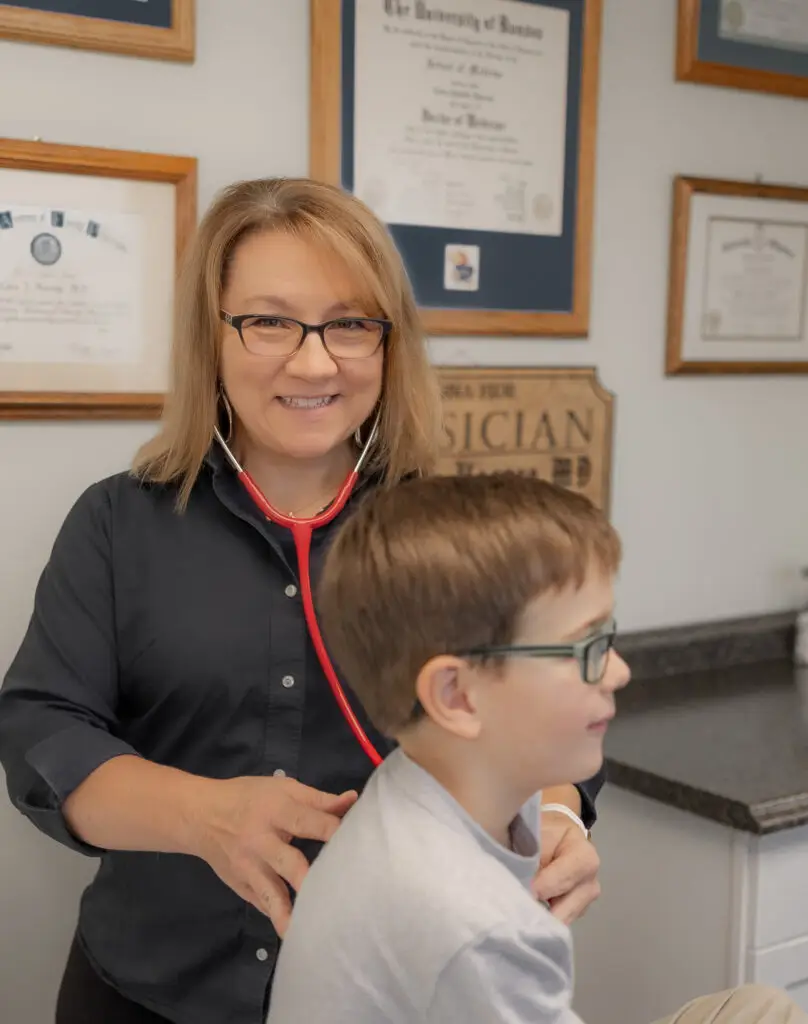 Dr. Harrop listening to a child's heartbeat with a stethoscope