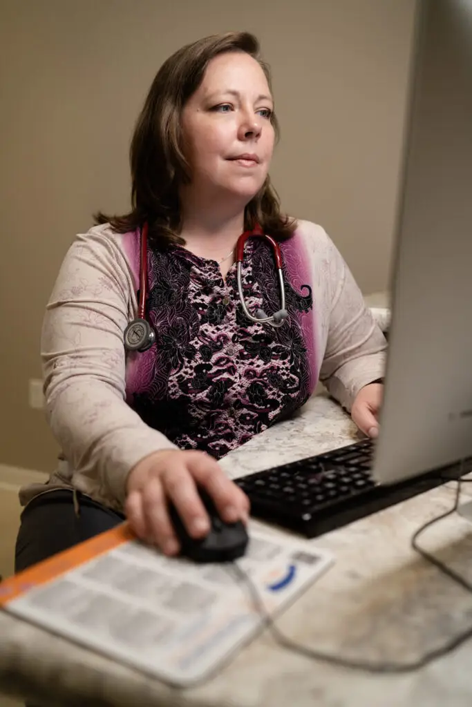 Dr. Nalda sitting at a desktop computer