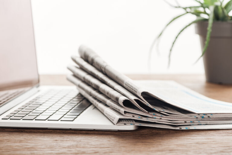 laptop-plant-and-stack-of-newspapers-on-wooden-ta-2024-11-18-02-17-21-utc_njainm-ghQuqy