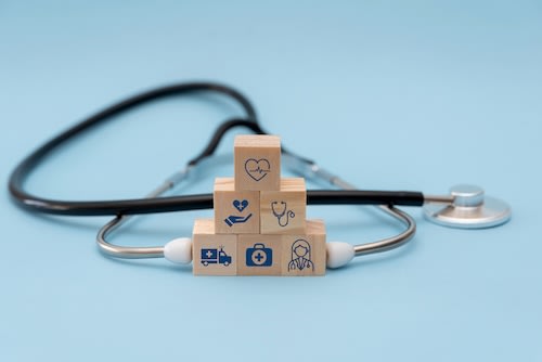 wooden-stacked-cubes-with-healthcare-icons-and-ste-2025-03-13-01-27-37-utc_qiqdx4-MFM1NG