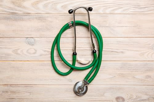 top-view-of-green-stethoscope-on-yellow-wooden-bac-2025-03-10-09-07-23-utc_qjw1wm-fTnak4