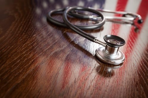 stethoscope-with-american-flag-reflection-on-woode-2026-03-09-03-25-51-utc_bkrc95-w0DGB4