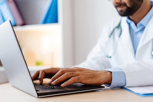 closeup-indian-doctor-in-white-coat-typing-on-ke-2025-02-20-10-55-23-utc_rk7eph-XeORFq