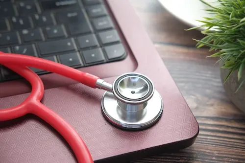 medical-stethoscope-on-laptop-on-wooden-table-2024-12-10-05-01-55-utc_ktngr5